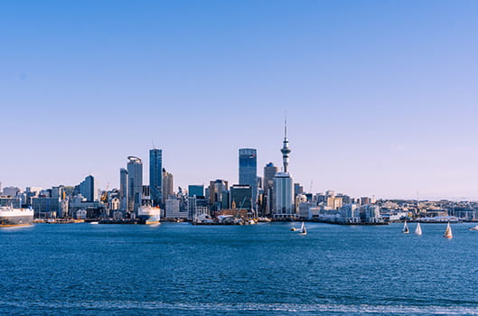 A wide view of Auckland, skyscrapers and tall buildings stretched with the sea in the foreground